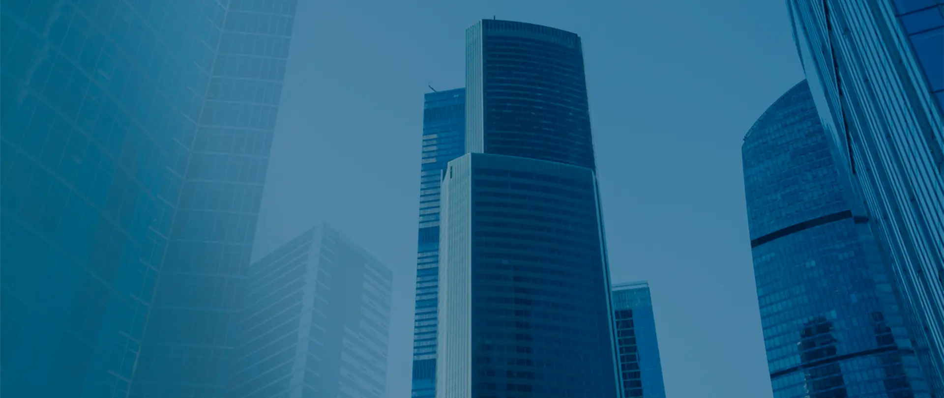 Edifícios corporativos vistos de baixo, em tons de azul